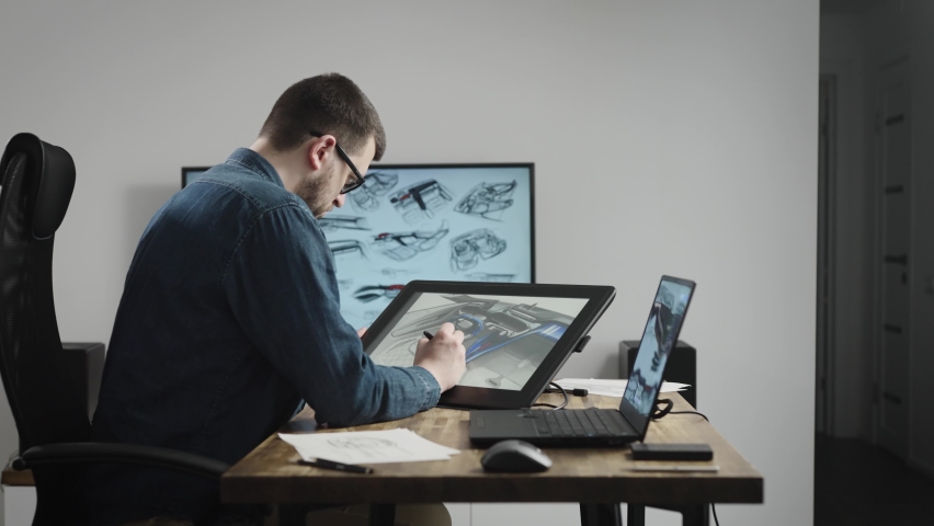 Industrial design studio with graphic tablet and computers. A senior designer draws a new car concept on a tablet. | Shutterstock HD Video #1090031699