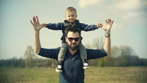 Happy Family Father Day And Child Son Leisure. Boy Son Sitting On Father Neck. Cute Little Kid Having Fun. Carefree Dad With Preschool Son Enjoy Activity Adventure. Family Parent Holidays Relationship