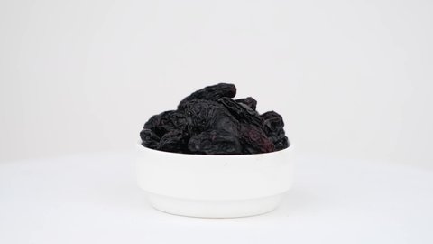 Black raisins isolated on a white background.