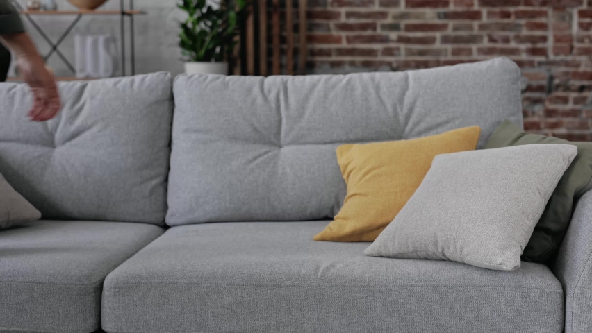 Exhausted overloaded young curly man in casual shirt came home after work flopped down on sofa feels like squeezed lemon. Concept of after party, tired overworked person hard day, lack of energy | Shutterstock HD Video #1090032951
