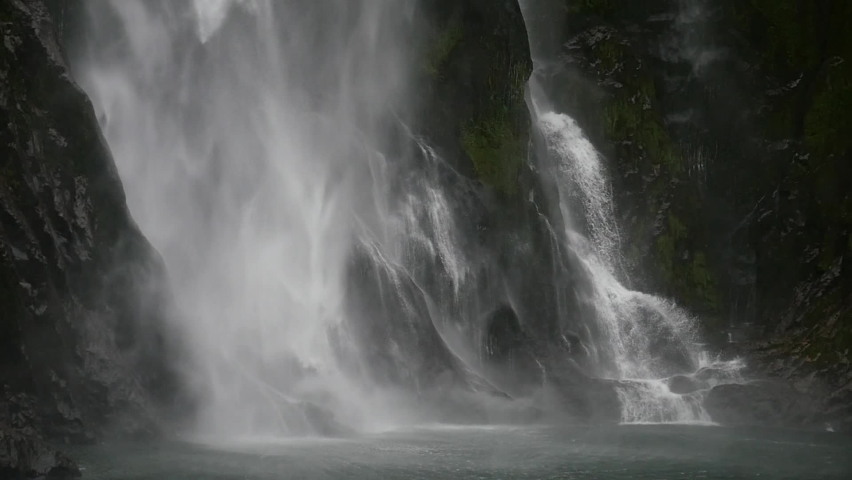 Rushing Waterfall Entering Water, Calming and relaxing beautiful water splashing into the ocean below Royalty-Free Stock Footage #1090033419