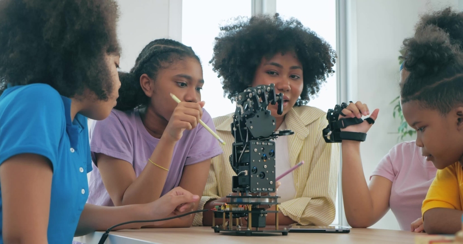 Group of African black teenager students learning about robotic arm school, Teacher assisting elementary students in robotics engineering classroom. Technology and Innovation concept. Royalty-Free Stock Footage #1090034893