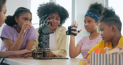 Group of African black teenager students learning about robotic arm school, Teacher assisting elementary students in robotics engineering classroom. Technology and Innovation concept. วิดีโอสต็อก