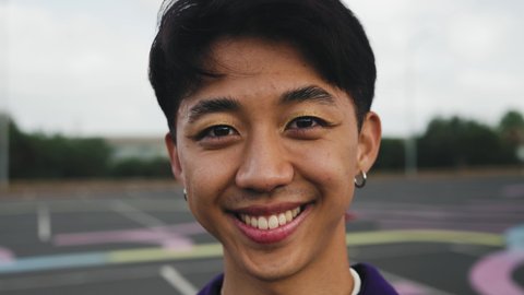 Happy Asian gay man smiling in front of camera