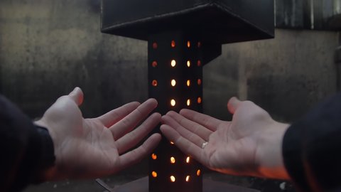 Mans hands are heating by the fire closeup