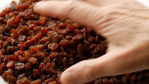 Take raisins from a plate.