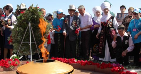 Bishkek, Kyrgyzstan - May 9, 2022: People putting carnations to the eternal flame on May 9 Victory Day