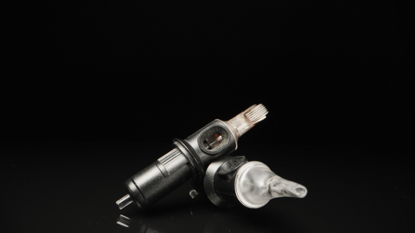 Needles for a tattoo machine, close-up. On a black background. Dolly slider extreme close-up.