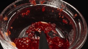 A jar of raspberry jam, spoon in the jar. Dolly slider extreme close-up inside. Laowa Probe
