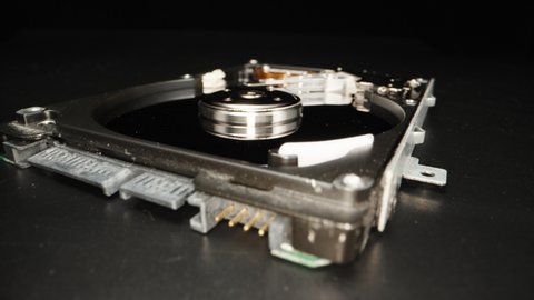 Disassembled computer hard drive, on a black background. Repair. Dolly slider extreme close-up. Laowa Probe