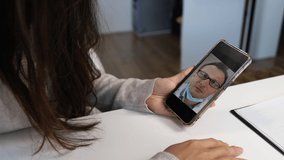 Woman Using Smartphone to Talk to His Doctor via Video Conference Medical App. Person Checks Symptoms, Talks with Physician, Using Online Video Chat Application