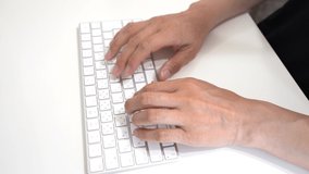 Japanese man typing with white keyboard.Close-up of the hand part