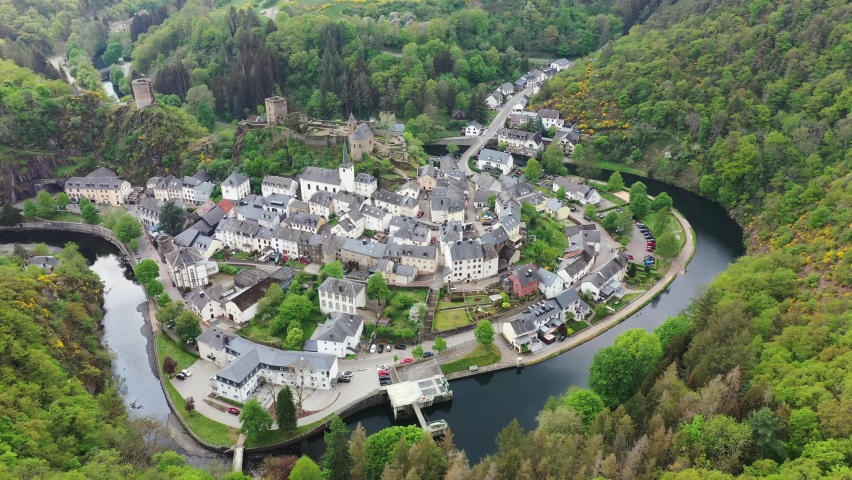 Aerial view of Esch-sur-Sure, medieval town in Luxembourg, dominated by castle, canton Wiltz in Diekirch. Forests of Upper-Sure Nature Park, meander of winding river Sauer, near Upper Sauer Lake.