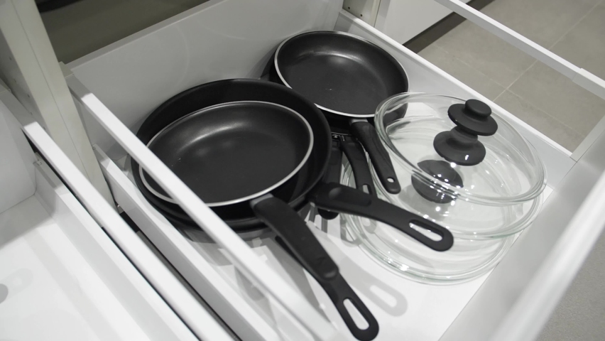 Kitchenware. Utensils for cooking in a box. Utensils in the kitchen. Frying pans, plates, pots. Royalty-Free Stock Footage #1090045359