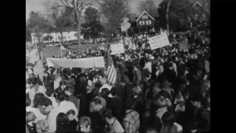 CIRCA 1960s - A pro-Vietnam War rally is held in Wakefield, Massachusetts, where people wave American flags.