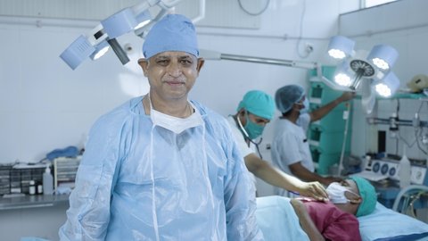 happy smiling Confident surgeon at operation theater standing by looking camera with crossed arms - concept of healthcare professional, medicare service and specialist.