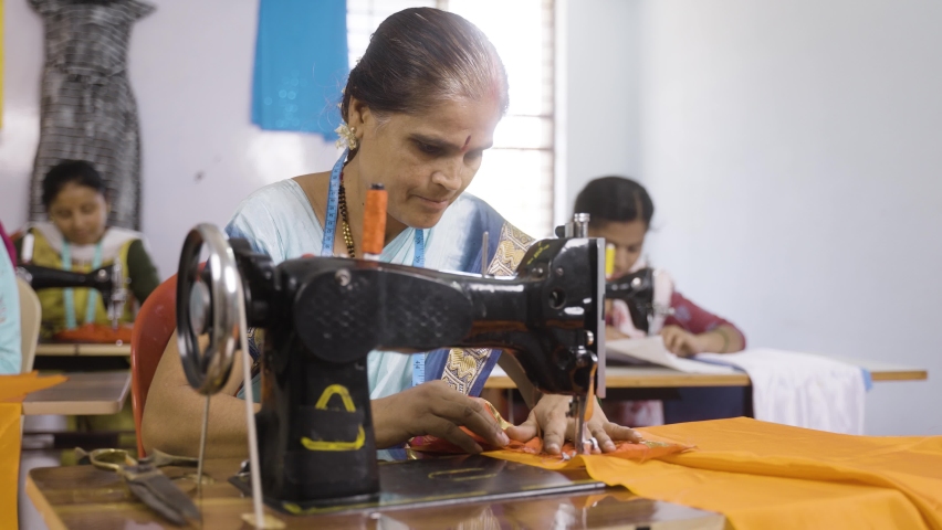 Group of women employees at garments busy working on sewing machine - concept of employment, job and stitching and tailoring industry | Shutterstock HD Video #1090047611