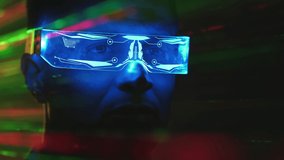 The close up view on a man in futuristic glasses on a color rays background