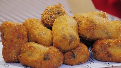 Homemade traditional Spanish croquettes or croquetas on street food festival. Tapas food.