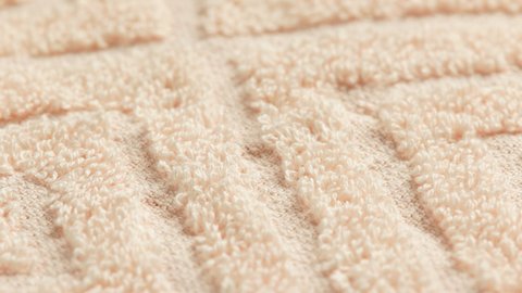 closeup loopable full-frame background of beige soft cotton towel with diamond pattern