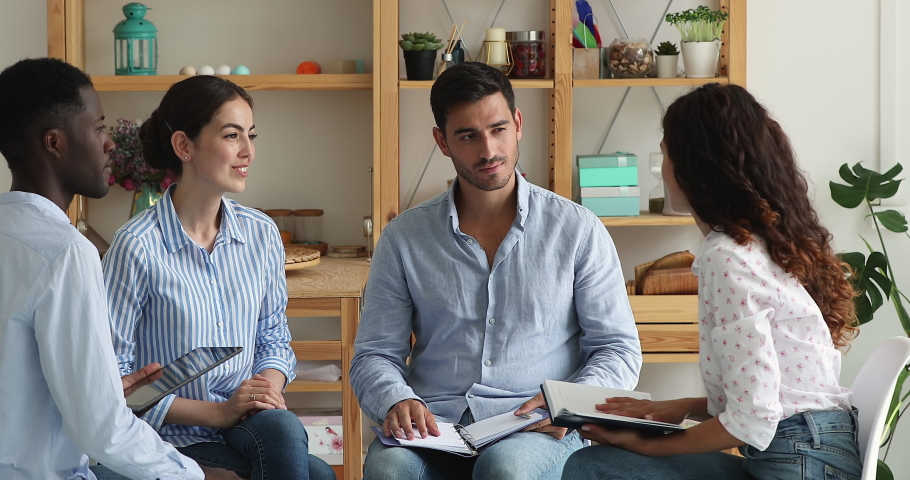 Young Latin woman hold paper planner propose effective solution innovative decision to department staff gathered on meeting. Male team leader shake female worker hand impressed with good idea offered Royalty-Free Stock Footage #1090056177