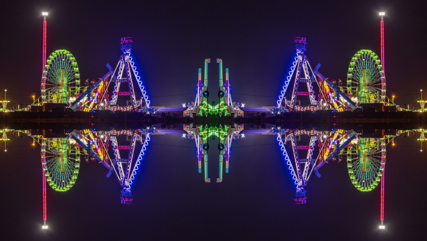 A timelapse of the lit up rides at a funfair in barcelona made into abstract mirrored pattern 