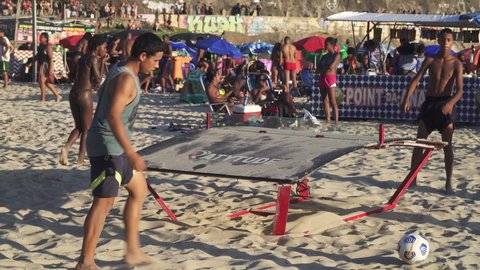 RIO DE JANEIRO, BRAZIL - FEBRUARY 2022: Two young men play Teqball at the Copacabana beach in Rio de Janeiro.