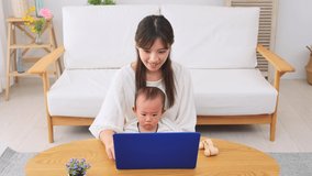 Asian mother watching the smartphone with her baby at home