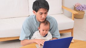 Asian father watching the smartphone with his baby at home