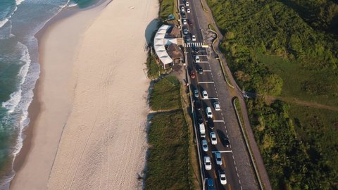 Aerial view of Reserva beach, Marapendi lagoon and car traffic on Lucio Costa avenue. Barra da Tijuca and Recreio, in Rio de Janeiro, Brazil. Sunrise. Sunny day. Drone take. Praia da Reserva.