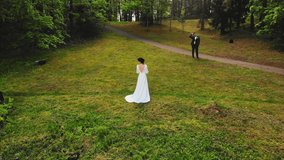 Aerial circle around bride posing for photographer in scenic forest nature in Lithuania countryside, Europe, Baltics