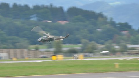 Zeltweg, Austria SEPTEMBER, 6, 2019 Military helicopter in flight at high speed low altitude and landing in a green alpine valley. Agusta Bell AB 212 UH-1N Twin Huey of Austrian Air Force