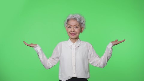 Elderly Asian woman. Green background for chroma key compositing.