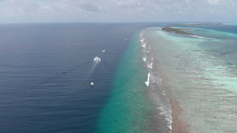 Boats next to island in maldives drone  aerial shot next to luxury resort