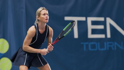 Female Tennis Player Hitting Ball with a Racquet During Championship Match. Professional Woman Athlete Successfully Receives Strike. World Sports Tournament. Slow Motion Medium Shot Playback