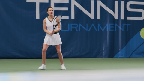 Female Tennis Player Hitting Ball with a Racquet During Championship Match. Professional Woman Athlete Receives and Lands Perfect Smash Shot. World Sports Tournament. Slow Motion Full Shot Playback