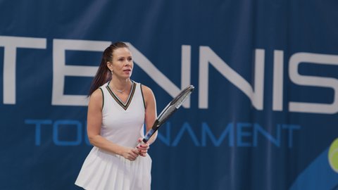 Female Tennis Player Hitting Ball with a Racquet During Championship Match. Professional Woman Athlete Receives and Lands Perfect Backhand Shot. World Sports Tournament. Slow Motion Full Shot Playback