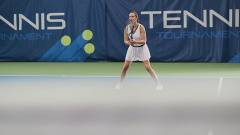 Female Tennis Player Hitting Ball with a Racquet During Championship Match. Professional Woman Athlete Receives and Lands Perfect Volley Shot. World Sports Tournament. Slow Motion Full Shot Playback