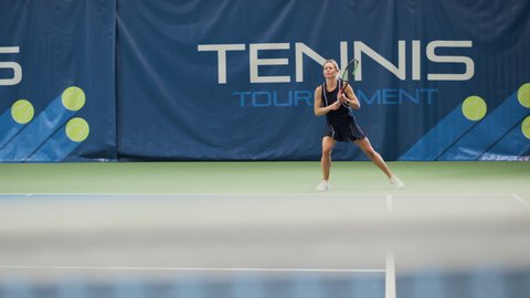 Female Tennis Player Hitting Ball with a Racquet During Championship Match. Professional Woman Athlete Receives and Lands Perfect Shot. World Sports Tournament. Slow Motion Long Wide Shot Playback