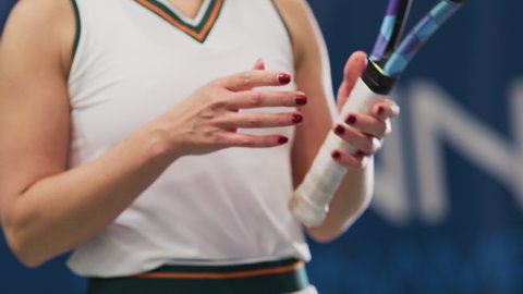 Female Tennis Player Holding the Racquet During Championship Match, Ready for Receive Ball Strike and Score. Professional Woman Athlete. Sports Broadcasting on TV. Slow Motion Focus on Hands Close-up