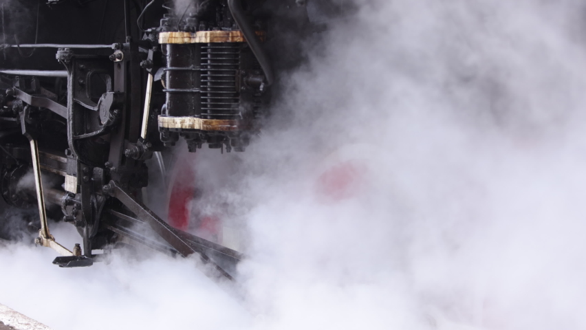 Vintage steam train locomotive. Pair locomotive train leaking smoke, steam ignited from behind. Antiquarian black steam engine. Old vintage train on the railroad. Close-up Royalty-Free Stock Footage #1090078179