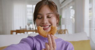 Young vlogger asia people influencer girl take photo eat bite smiley donut funny face post review on   reel app Sweet tooth food sugar lover enjoy fun show viral video camera at home