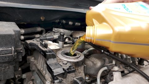 Pruszcz Gdanski, Poland - May 7, 2022: Pouring Petronas car oil into car engine.