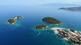 Drone shot of Ksamil, Albania - drone is reversing, facing some islands, passing hotels and beaches. Snippet could ideally be used for travel related videos or movies.