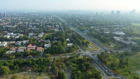 Aerial Panning Over A Highway And Sprawling City On A Hazy Morning With Highrise Towers In The Distance - Islamabad, Pakistan