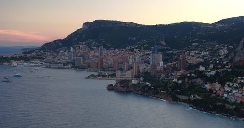 Aerial Tilt Up Beautiful Shot Of Harbor By City On Mountains During Sunset - Monaco