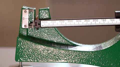 Manual mechanic weight scale for gunpowder - Arm slowly moving towards zero when gunpowder amount is exactly correct - Static closeup of ammunition home reloading process