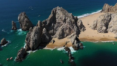 Cinematic drone shot of sea cliffs with Playa del Amor and El Arco in view in Cabo San Lucas Mexico, descending slowly