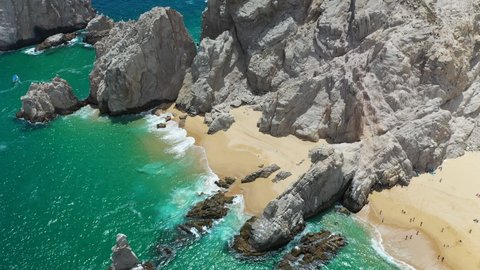 Cinematic drone shot of sea cliffs and beautiful beaches in Cabo San Lucas Mexico, rotating