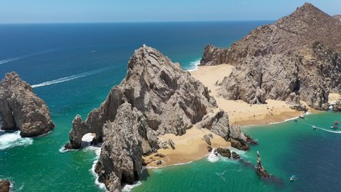Drone shot of Playa del Amor and El Arco, a natural archway in the sea cliffs, in Cabo San Lucas Mexico, revealing